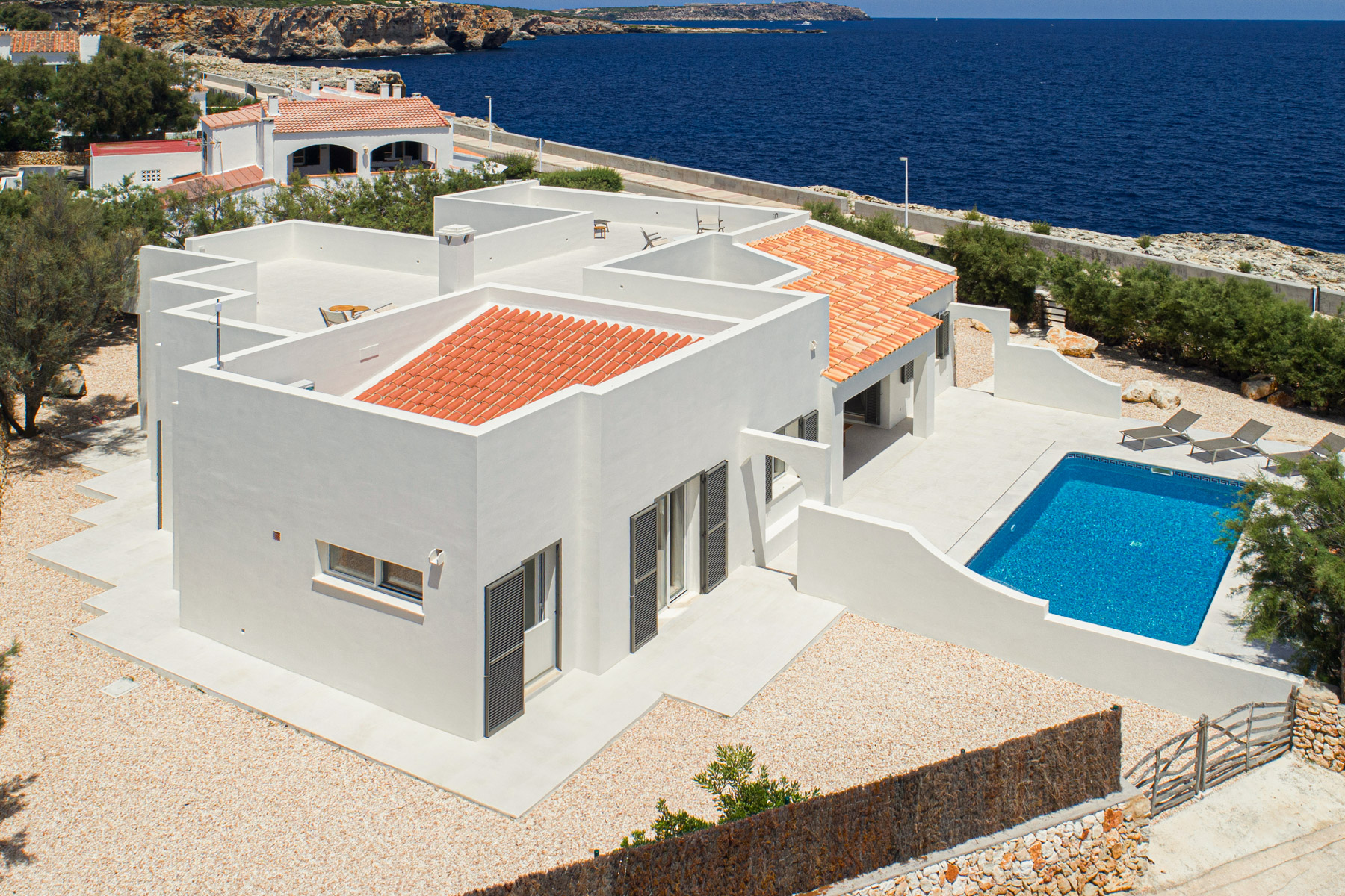 Disfrute de las vistas panorámicas al mar desde la terraza privada de esta impresionante villa moderna en primera línea de playa en Menorca.