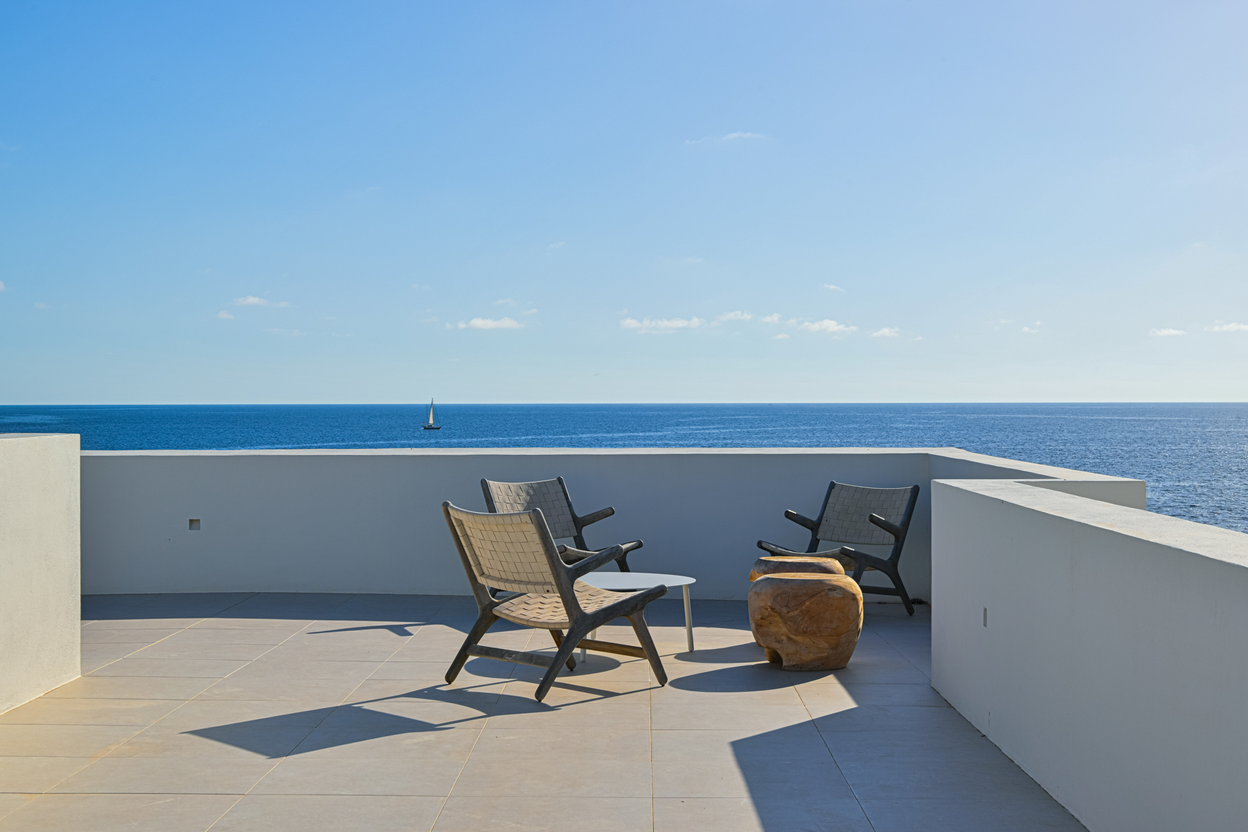 Disfrute de las vistas panorámicas al mar desde la terraza privada de esta impresionante villa moderna en primera línea de playa en Menorca.