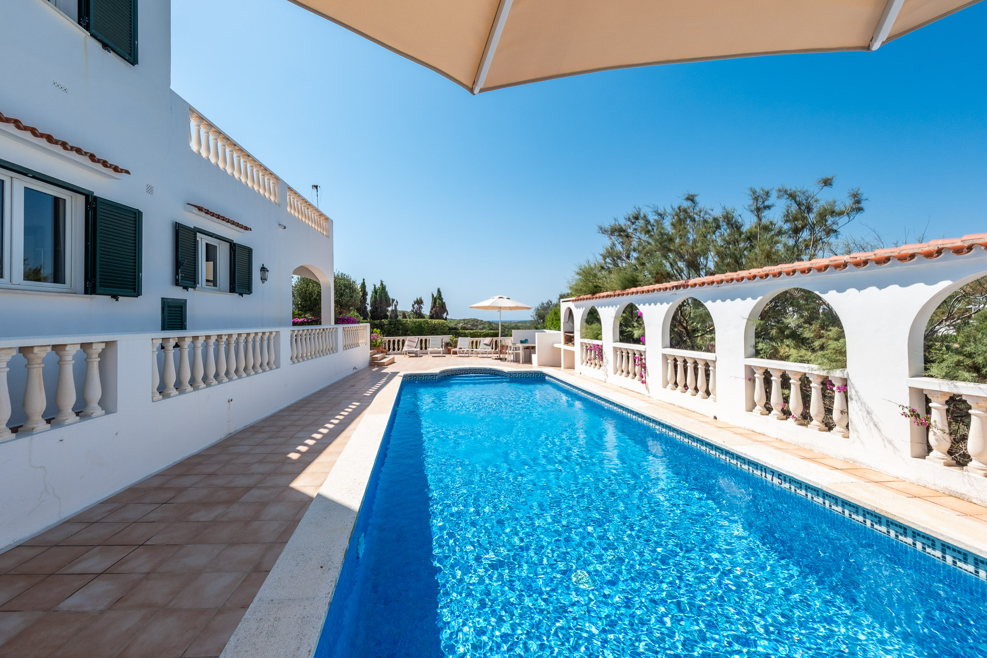 Villa elevada en Cala Llonga con vistas al mar y al puerto de Mahón, y una gran terraza con piscina para disfrutar.
